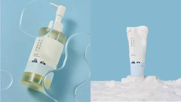 Korean skincare cleanser and foaming wash with minimalist packaging on blue background