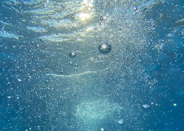 Bubbles rising through blue water for a skincare article about toner