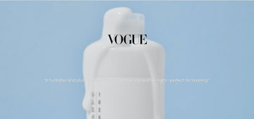 White milky toner bottle on a blue background with Vogue text and a quote about hydration and lightweight layering