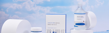 Front view of Round Lab skincare products showcasing white packaging with a blue sky background