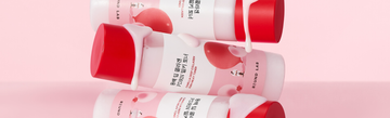 Round Lab PDRN Collagen Milky Toner bottles with milky liquid on a pink background
