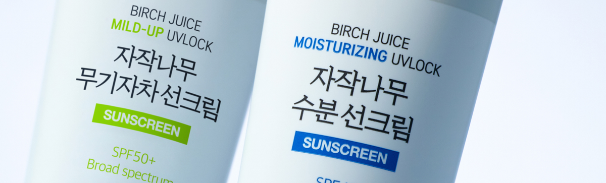 Close-up of two Birch Juice sunscreen tubes labeled Mild-Up UVLock and Moisturizing UVLock