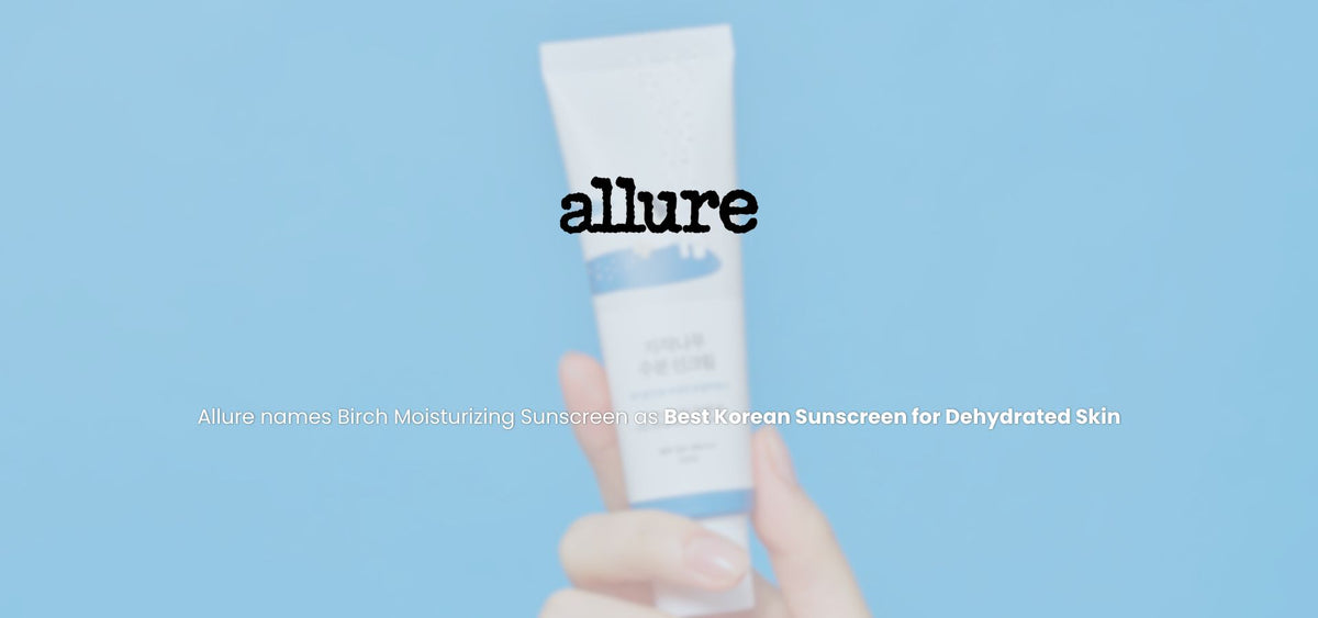 Front view of ROUND LAB Birch Moisturizing Sunscreen UVLock tube held in a hand against a blue background