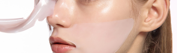 Close-up of a person applying a translucent hydrating face mask sheet for skincare
