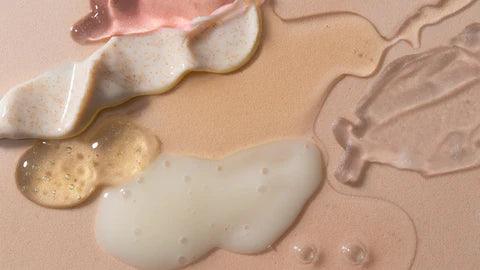Various skincare product textures and serums in pastel tones on a nude background