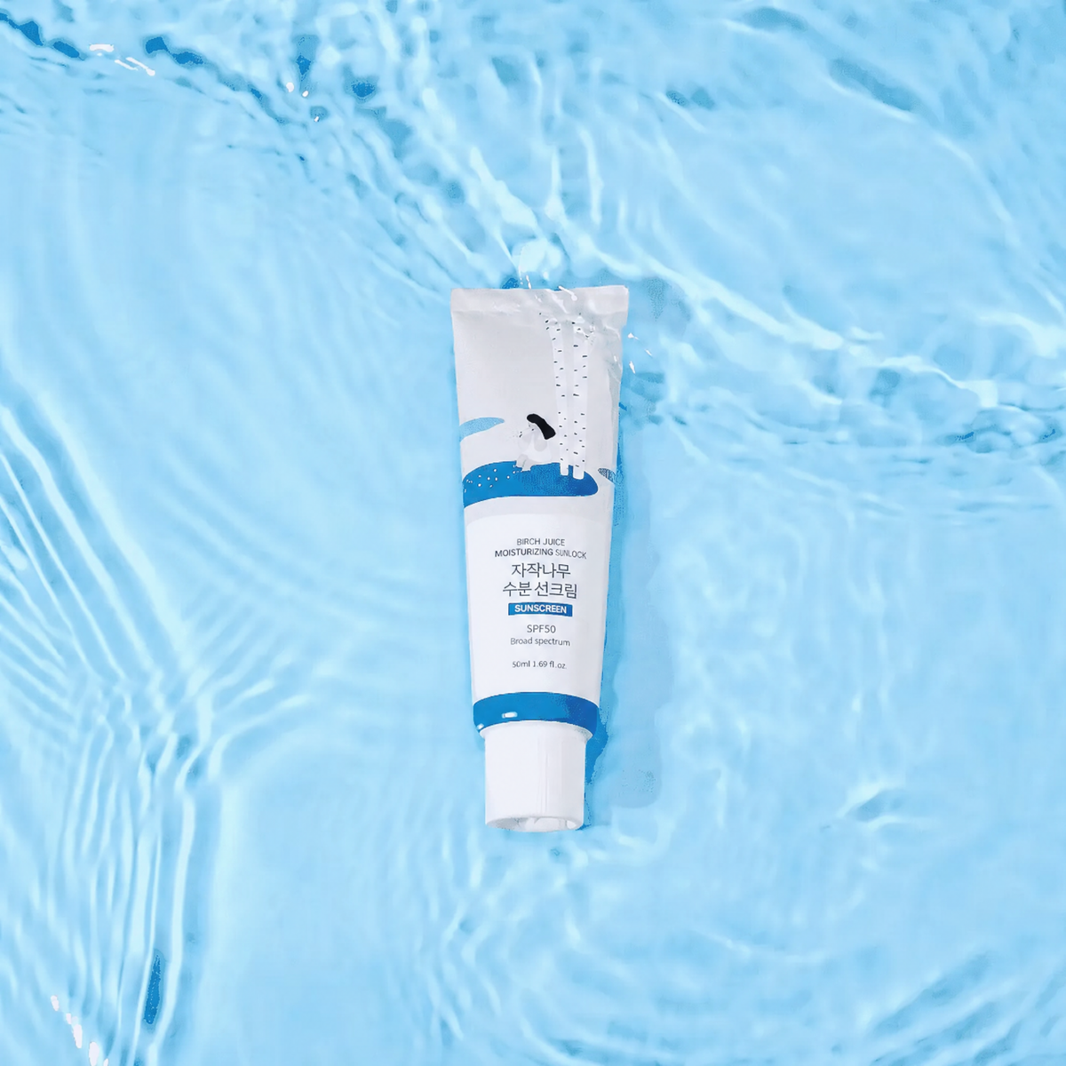 Birch Sunscreen UVLock SPF 50 – white and blue 50 ml tube lying in clear, rippling light blue water